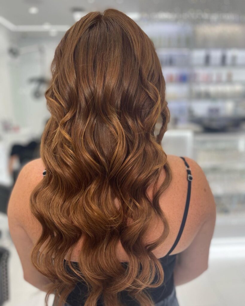 Long auburn hair styled in flowing waves