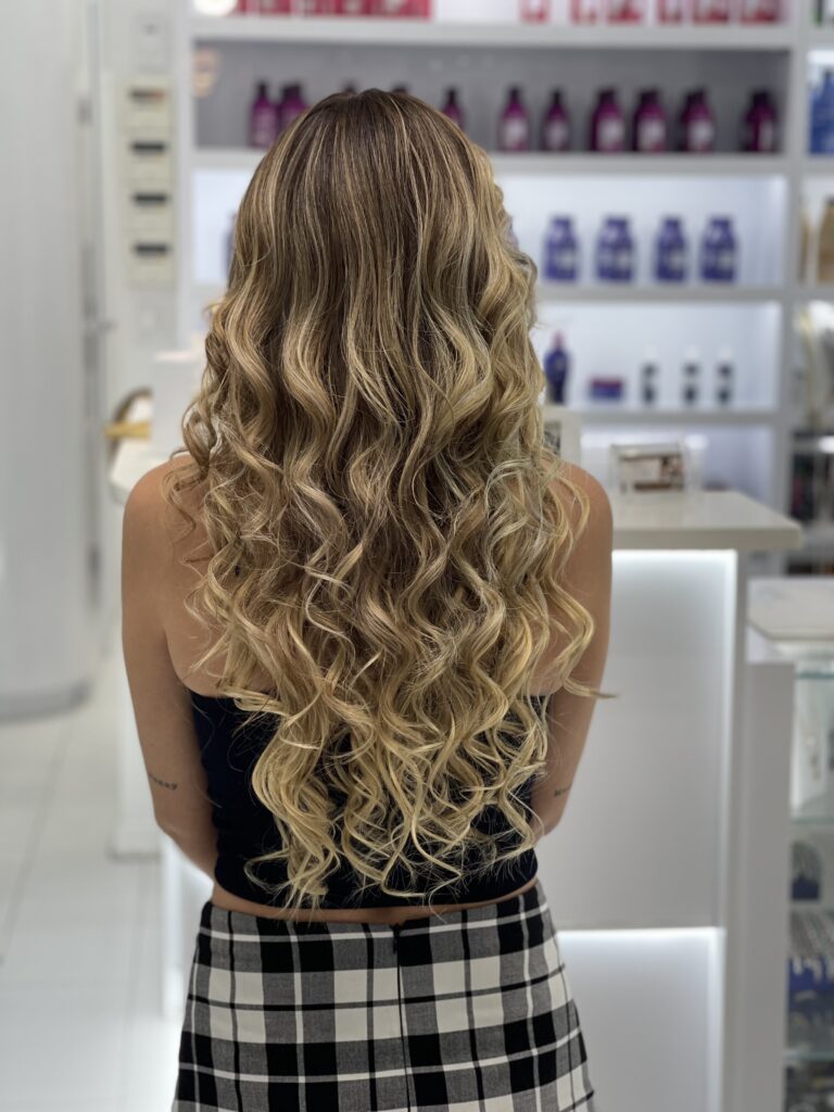 Long highlighted brunette hair styled in waves