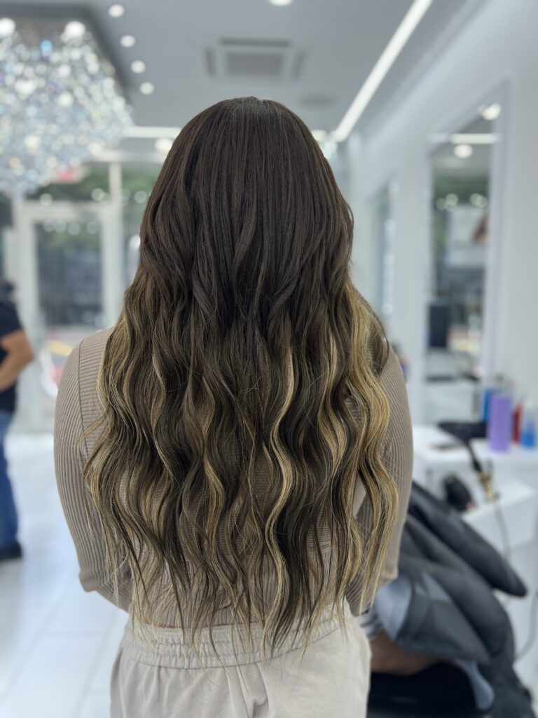 Long dark hair with caramel highlights and soft waves