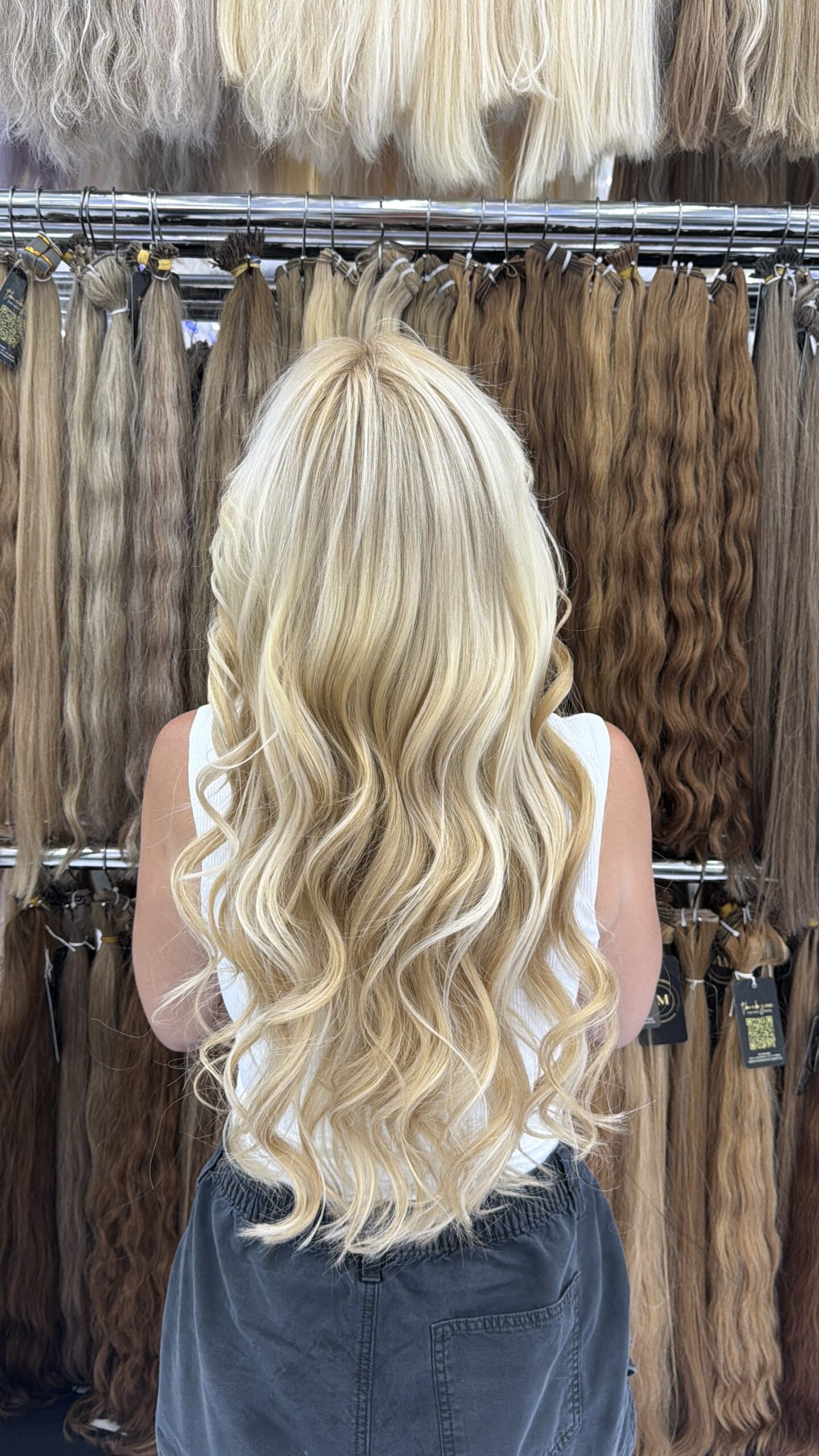 Long blonde hair styled in loose cascading waves at 23rd Street Hair Salon