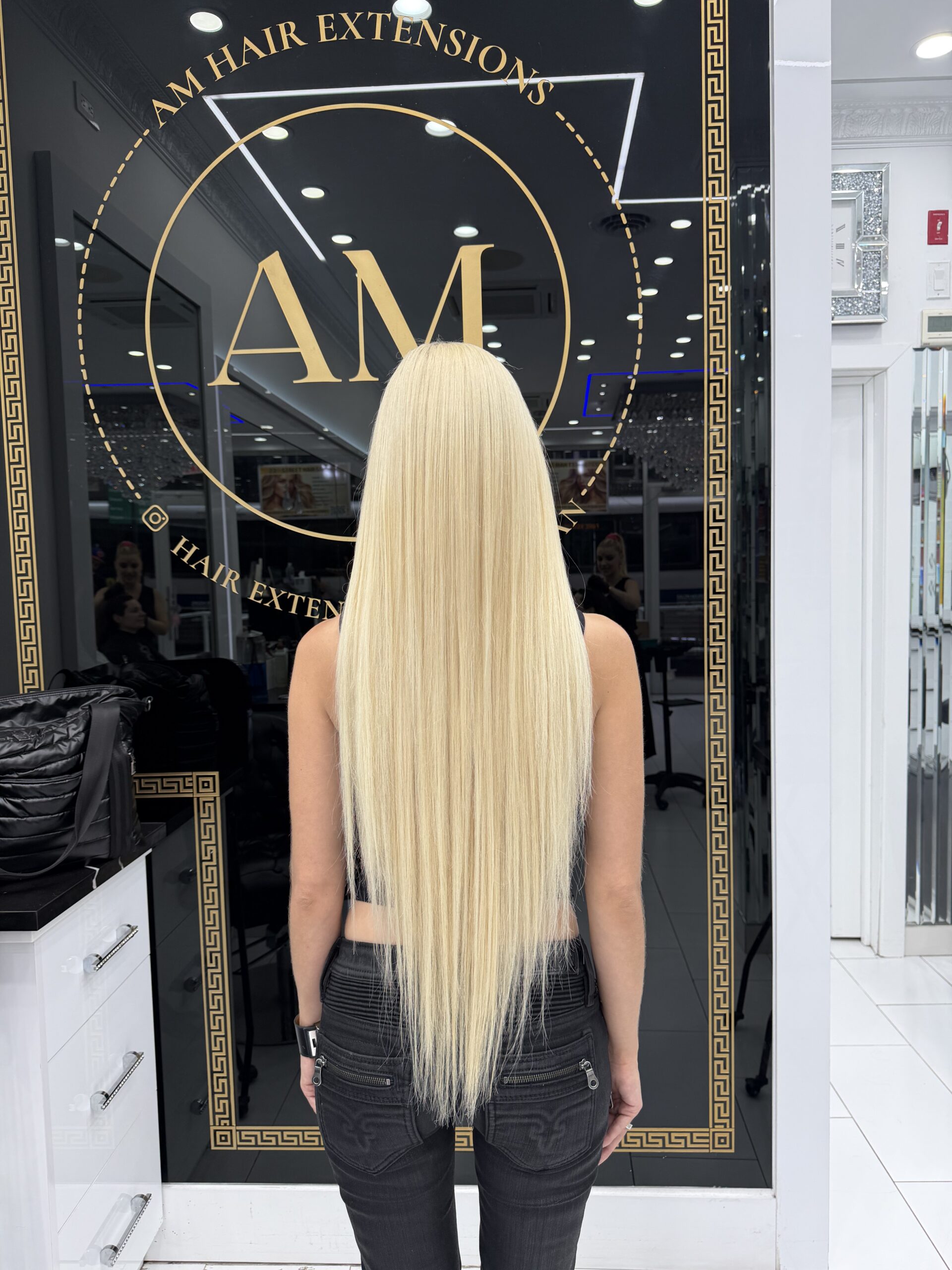 Long straight blonde hair with a sleek finish at 23rd Street Hair Salon
