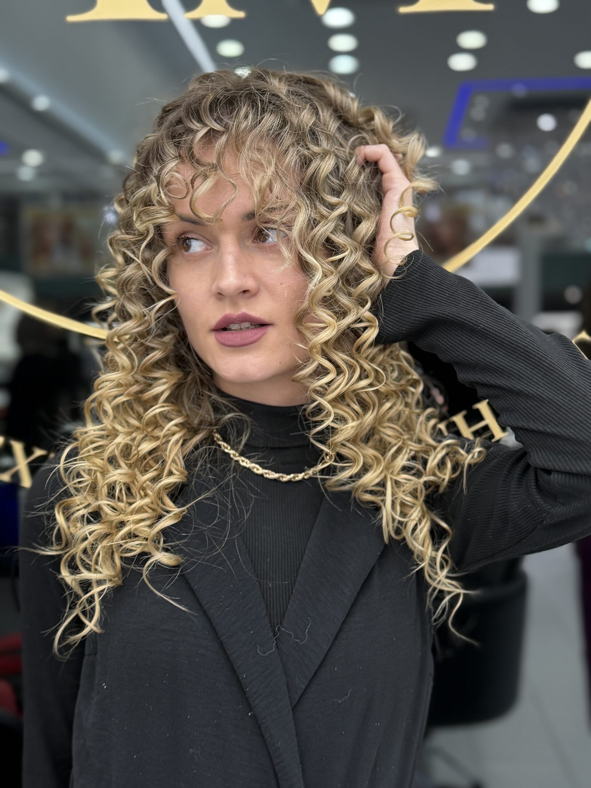 Defined spiral curls with blonde highlights at 23rd Street Hair Salon