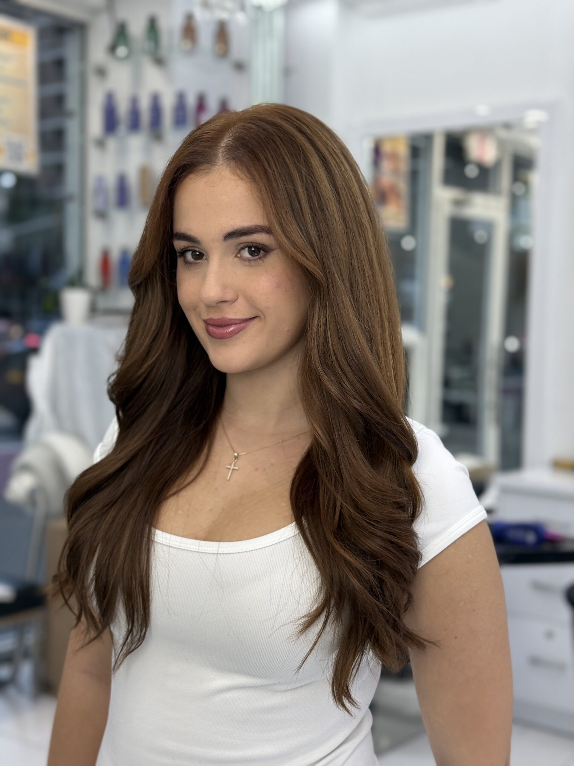Long chestnut brown hair styled in soft, voluminous waves
